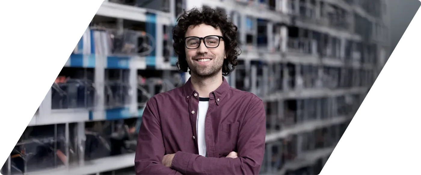 Smiling IT freelancer with crossed arms in a server room